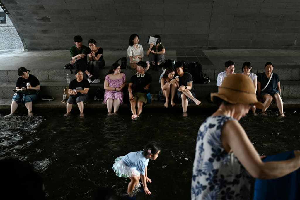 People cool off under a bridge over the Cheonggyecheon Stream in Seoul