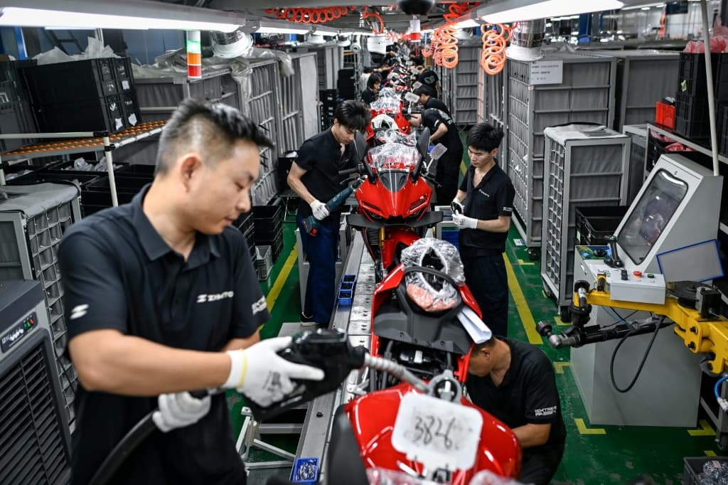 Workers assemble motorcycles at the ZXMoto factory in Chongqing, southwestern China